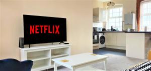 una sala de estar con TV con el cartel de netflix. en Shakespeare Views - Modern Northampton Apartment, en Northampton