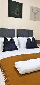 Un dormitorio con dos camas con almohadas azules. en Shakespeare Views - Modern Northampton Apartment, en Northampton