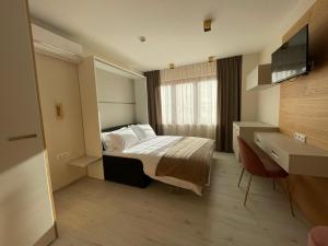 una camera d'albergo con un letto e una televisione di Albergo Aida a Lussemburgo