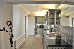 a kitchen with a mural of a woman on the wall at Trafford Terrace Davyhulme in Urmston