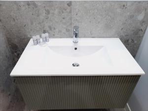 - un lavabo blanc dans la salle de bains avec 2 bouteilles dans l'établissement Apartamentos Vega by gaiarooms, à Salamanque