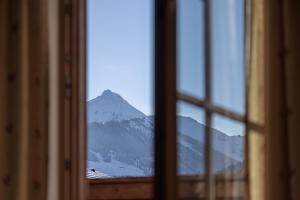 Blick auf einen Berg durch ein Fenster in der Unterkunft Wellnessappartements Margit in Alpbach