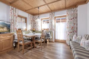 jadalnia ze stołem, krzesłami i kanapą w obiekcie Wellnessappartements Margit w Alpbach