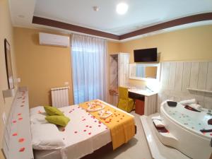 a bathroom with a tub and a bed and a sink at Hotel Garden Napoli in Naples