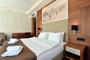 una camera da letto con un grande letto con due asciugamani di Hotel Lazaro a Podgorica