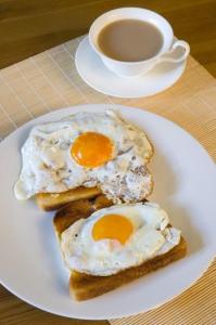 ナイロビにあるCasa Tranquilla - JKIAのパンに卵2つとコーヒー1杯を盛り付けた皿