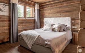 a bedroom with a bed in a wooden wall at L'Or des Cimes in Valloire