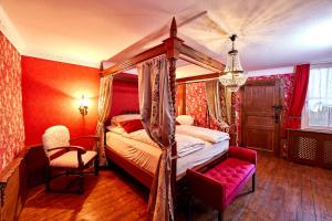 ein Schlafzimmer mit Himmelbett und Sessel in der Unterkunft Ritterstube - Eifelstuben mit Charme, Nähe See und Burg, außergewöhnlich, Vulkaneifel in Ulmen