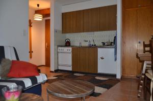 a kitchen with a couch and a table in a room at Immeuble Les Ecureuils in Les Collons