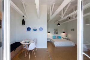 a white bedroom with a bed and a table at Ligia Waterfront Apartments in Lygia