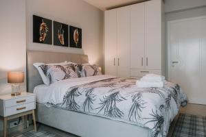 Nafplio Pleasure Stay II في نافبليو: غرفة نوم مع سرير وخزانة بيضاء