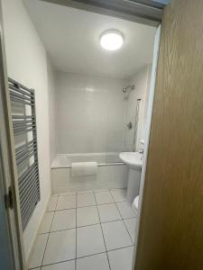 a bathroom with a tub and a toilet and a sink at Modern city centre 1 bed apartment with free on site parking by Lets Relocations in Birmingham