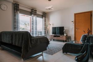 a living room with a couch and a tv at Nafplio Pleasure Stay II in Nafplio