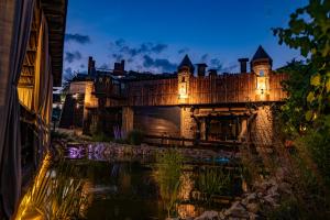 an old castle with lights on the water at night at Kodatskiy Kosh in Dnipro
