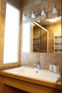 a bathroom with a sink and a large mirror at La tour Bocsozel in La Côte-Saint-André