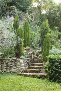 una escalera de piedra en un jardín con árboles y arbustos en La tour Bocsozel, en La Côte-Saint-André