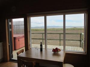 einen Tisch mit einer Schale Obst und einer Flasche Wein in der Unterkunft Langafjaran Cottages in Hjarðarfell