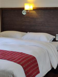 una camera da letto con un grande letto con un orologio sul muro di Bardia Forest Resort a Bardiyā