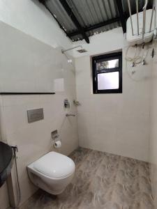 a bathroom with a toilet and a window at Bardia Forest Resort in Bardia