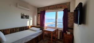 a bedroom with a window with a view of the ocean at Lale Pension in Egirdir