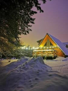 a log cabin in the snow at night at Domek Szałas "Jodłowe Izby" in Białka Tatrzanska