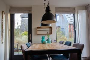 - une salle à manger avec une table et des chaises en bois dans l'établissement Duinroos Egmond, à Egmond aan den Hoef