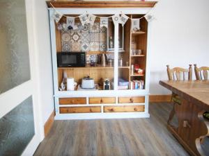 a kitchen with a large wooden cabinet with a counter at Florita - Dawlish in Dawlish