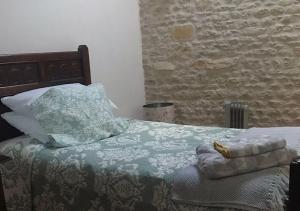 a bedroom with a bed with a blue and white comforter at Le Figuier - 4 bedroom Farmhouse Gite in Limalonges
