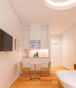 uma cozinha com uma mesa e duas cadeiras num quarto em Lisbon Serviced Apartments - Estrela em Lisboa