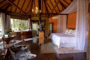 a bedroom with a bed and a table in a room at Pousada Infinito in Visconde De Maua