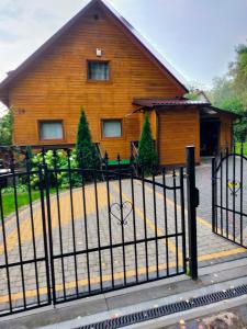 a house with a black fence in front of it at Drewniany domek w Otominie in Otomin +9 photos