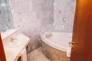 un bagno con una vasca bianca e un lavandino di Paul's Hotel a Knittelfeld