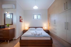 Ianthi Beach Villa في Kypseli: غرفة نوم عليها سرير وفوط