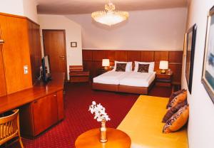 クニッテルフェルトにあるPaul's Hotelのベッドとテーブルが備わるホテルルームです。