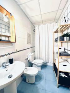 y baño con 2 aseos, lavamanos y espejo. en Apartamento Pintor Palomino, en Córdoba