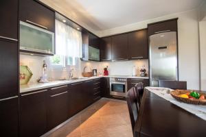 a kitchen with dark wood cabinets and a counter top at Ianthi Beach Villa in Kypseli