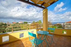balkon z niebieskim stołem i krzesłami w obiekcie Ianthi Beach Villa w mieście Kypseli