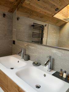 a bathroom sink with two faucets on top of it at Le Refuge des Sens chalet Sérénité in Vaujany