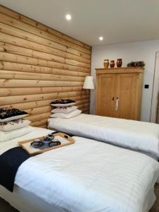ザコパネにあるAnielki Apartamentの木製の壁の客室内のベッド2台