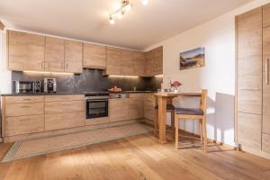 a kitchen with wooden cabinets and a wooden table at Das Alpbach Juwel in Alpbach