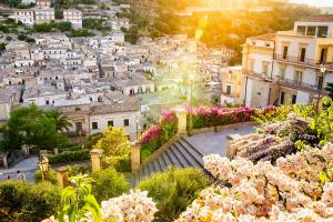 a view of a city with flowers and buildings at San Giorgio Modica Hotel in Modica