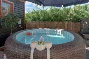 a jacuzzi tub with two wine glasses in it at Kuća za odmor Rukova Hiža, sauna, jacuzzi in Donja Stubica