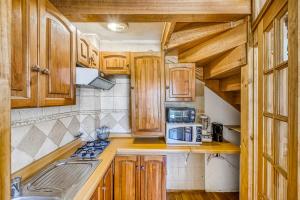 a small kitchen with wooden cabinets and a sink at Loft Costero with Parking Wifi View & TV in Viña del Mar