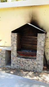 - une cheminée en pierre installée sur le côté du bâtiment dans l'établissement Camping Paleochora, à Paleóchora