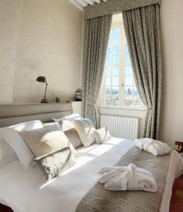a bedroom with a large white bed with a window at Chambres d'hôtes Relais Mira Peis in Mirepoix