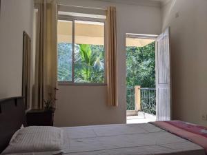 a bedroom with a bed and a large window at Tangerine Stay - Friends & Family 4BHK Villa, Goa in Dabolim
