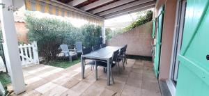 stół i krzesła na patio w obiekcie Villa en duplex très calme en résidence privée avec piscine - M65 w mieście Saint-Cyprien