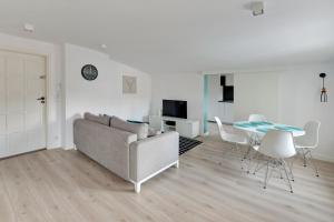 uma sala de estar com um sofá, uma mesa e cadeiras em Grand Apartments - City Centre Apartment em Sopot