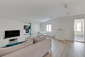 a living room with a couch and a tv at Grand Apartments - City Centre Apartment in Sopot