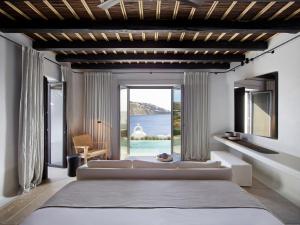 a living room with a couch and a large window at Kalesma Mykonos in Ornos